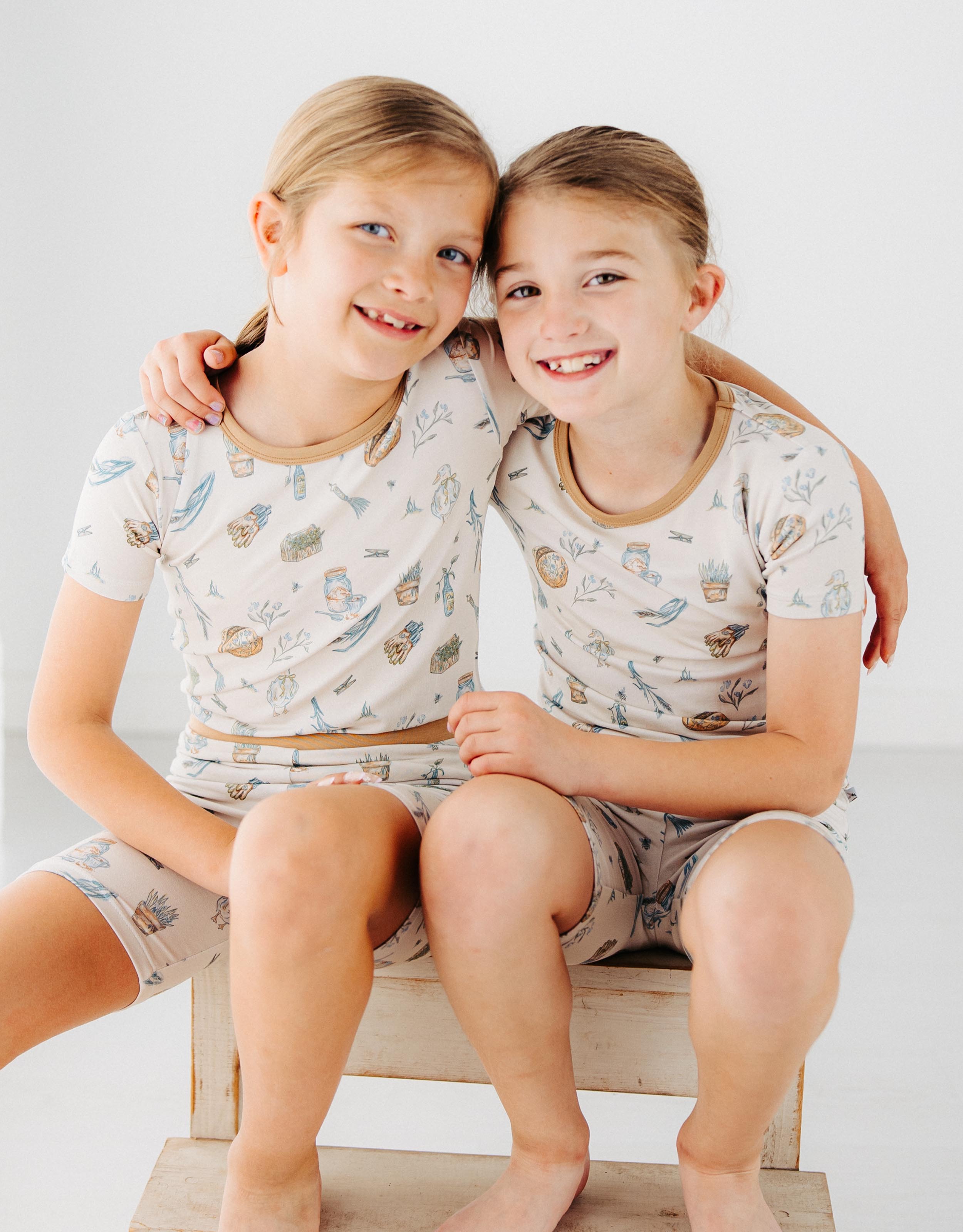 two girls wearing Meadow Lane Kids Heirloom Homestead TENCEL kids short sleeve shirt and shorts pajamas