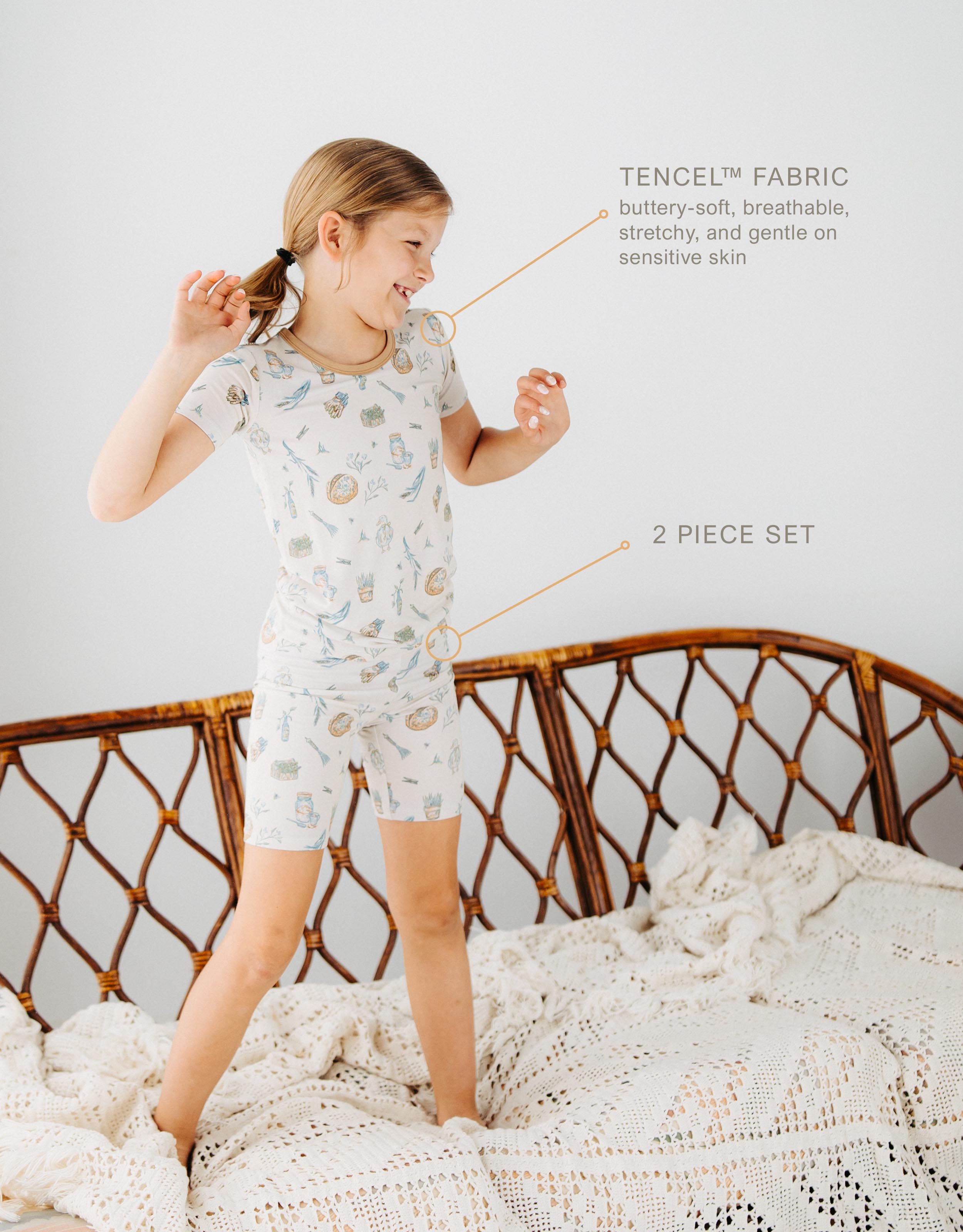 girl standing on couch wearing Meadow Lane Kids Heirloom Homestead kids short sleeve and shorts kids pajamas