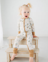 little girl sitting on a step in Meadow Lane Kids Heirloom Homestead TENCEL toddler sleeper